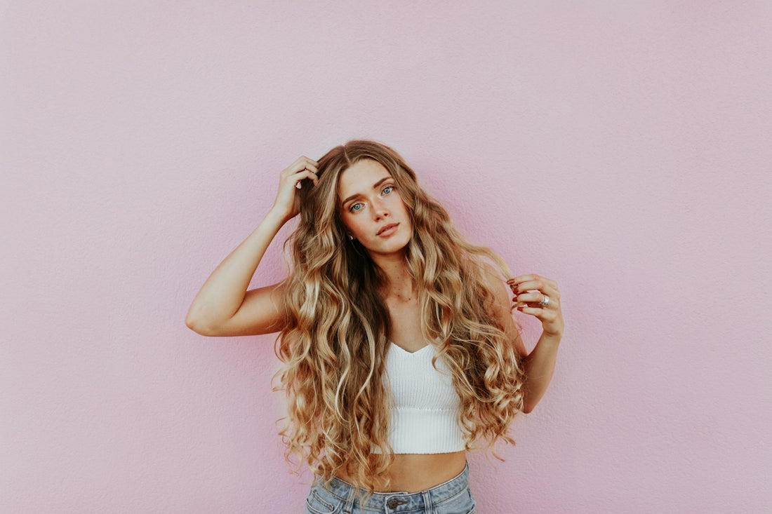 Frau mit langem Haar an einer rosa Wand