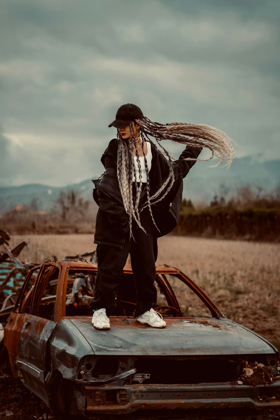 a man with dreadlocks standing on top of a car