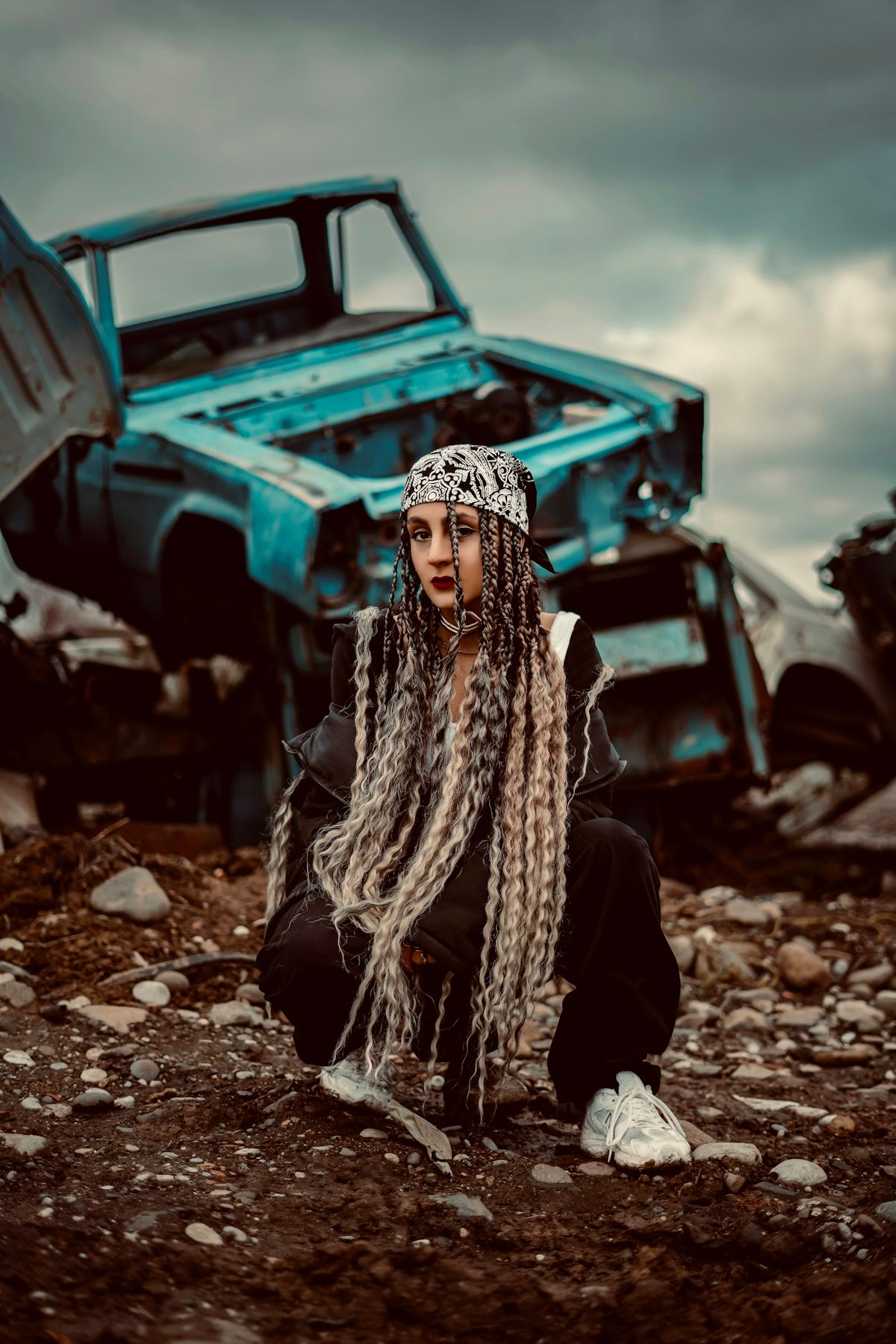 a woman with dreadlocks sitting in front of a truck
