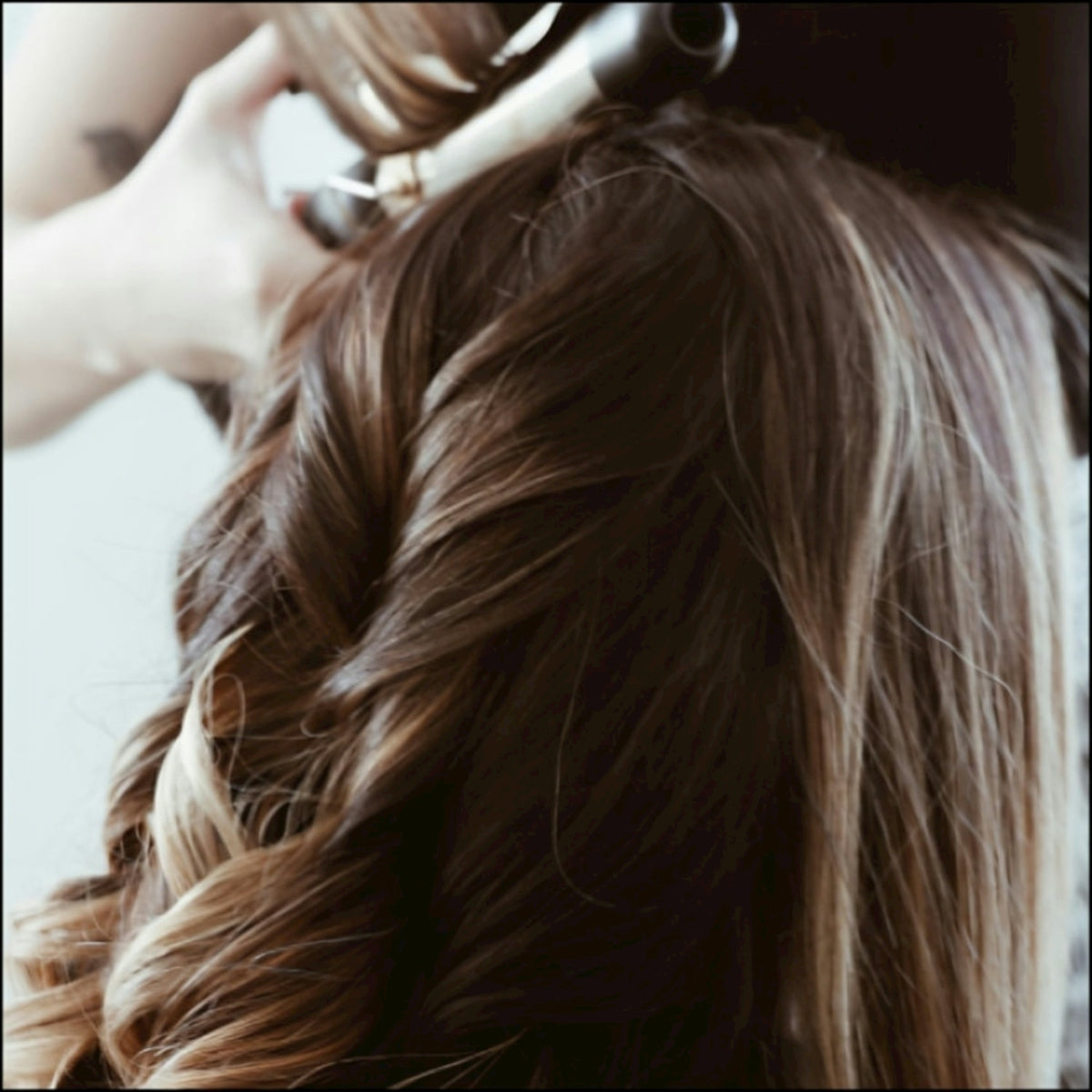 A woman getting her hair done by a hair stylist