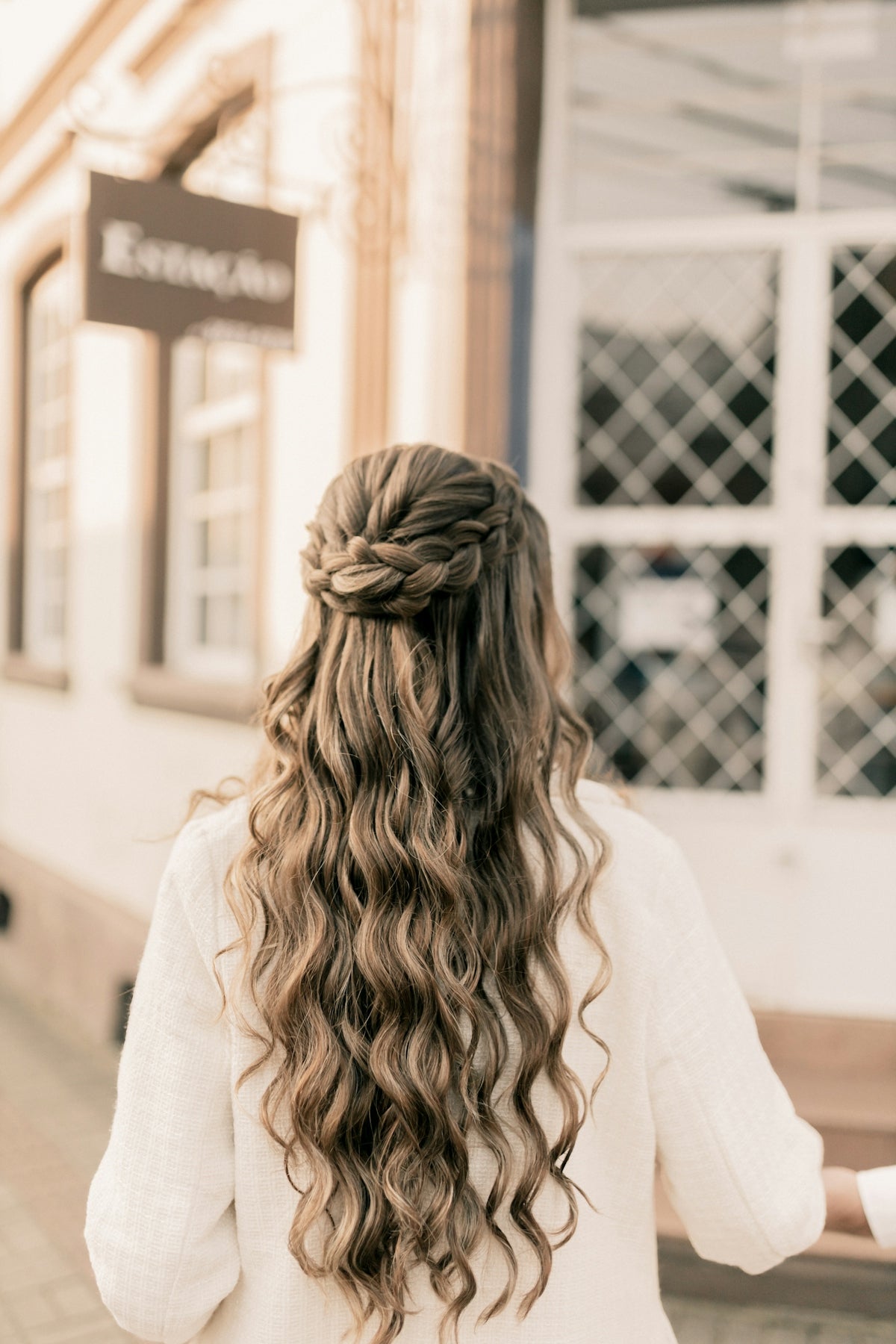 A woman with long hair walking down a street