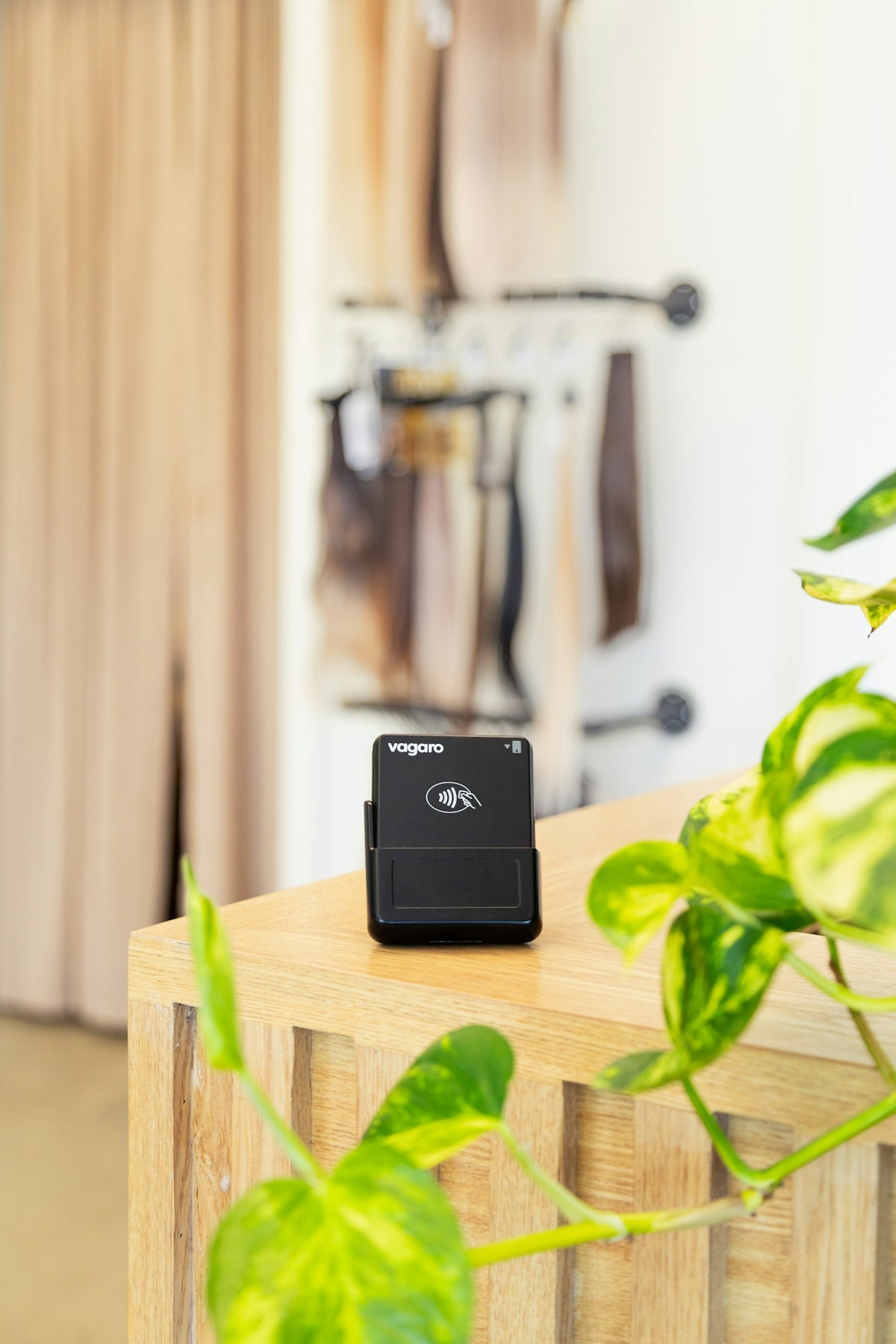 A credit card reader sits on a wooden counter