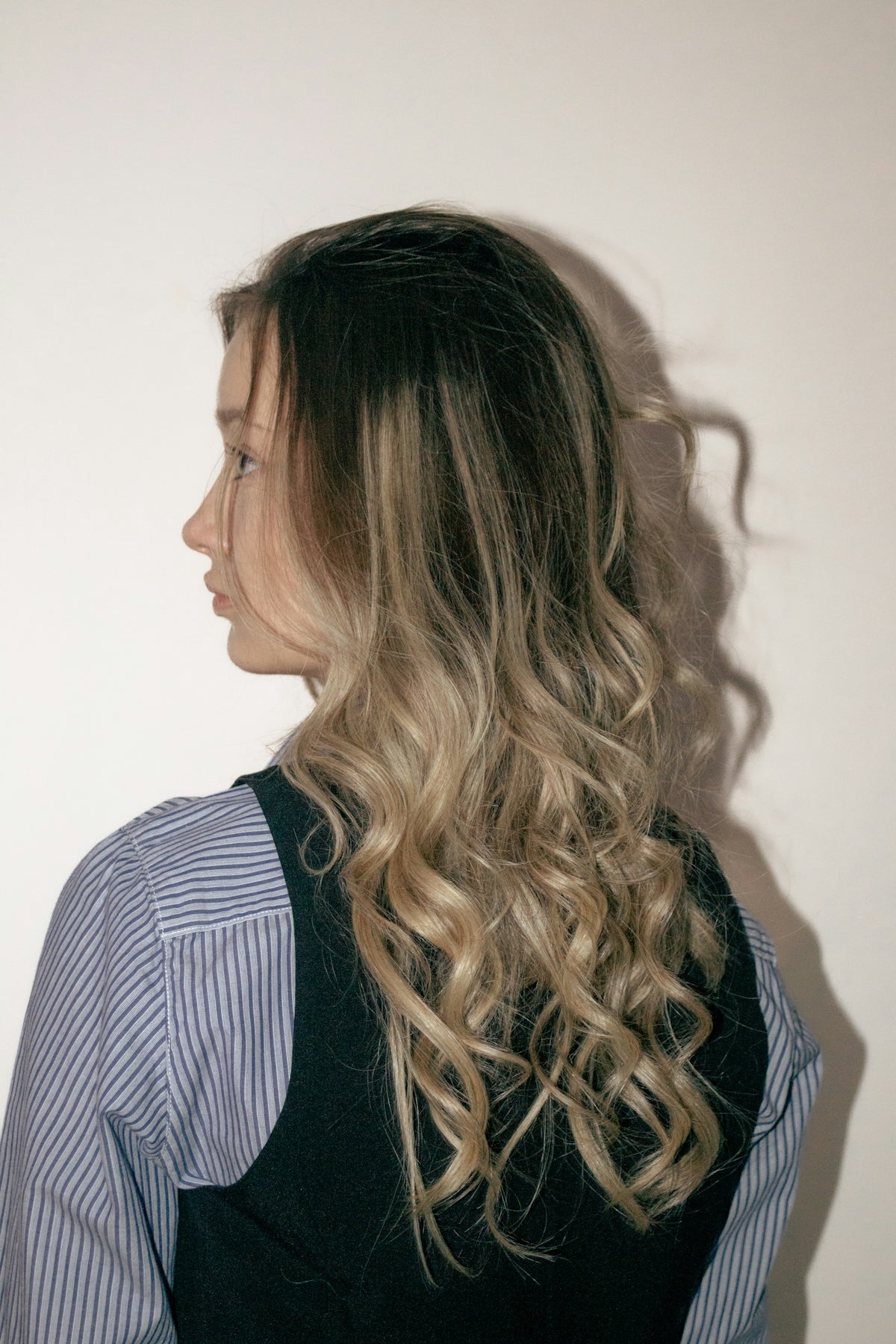 A woman with curly hair looks to the side.