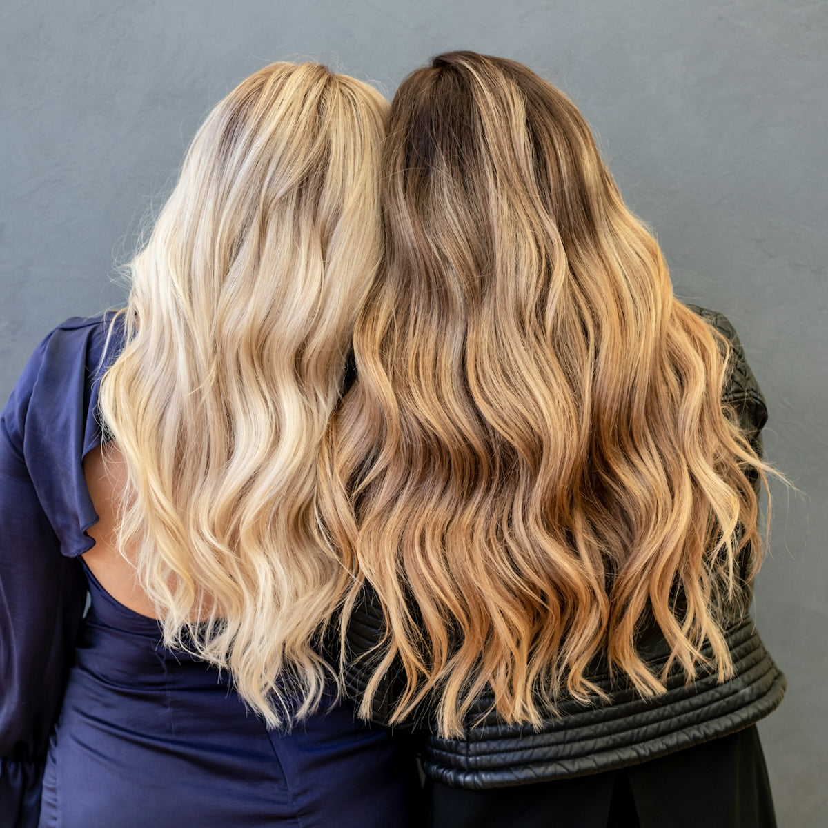 Zwei Frauen mit langem, gewelltem blondem und braunem Haar