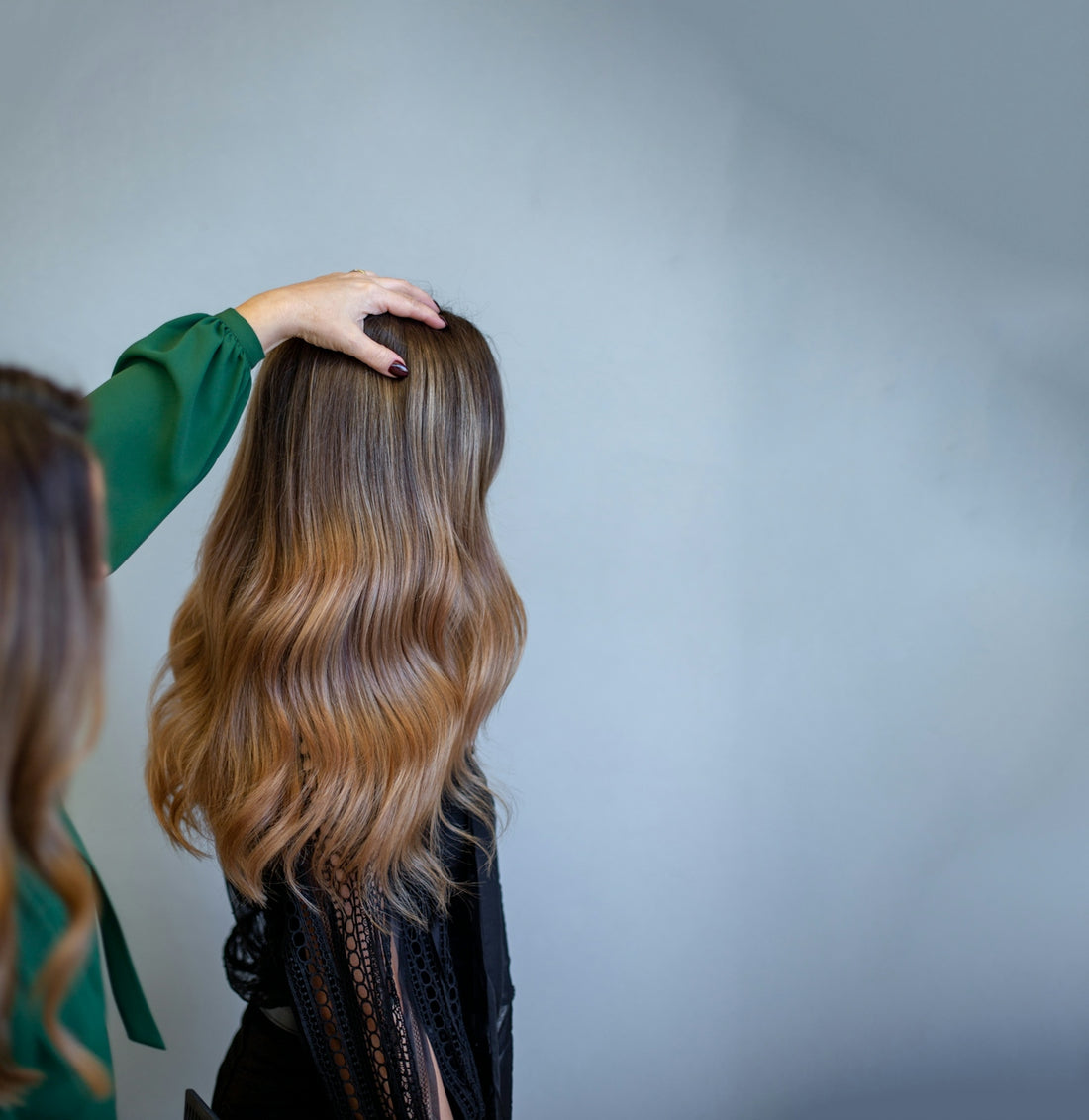Hand auf langem, gewelltem Ombre-Haar