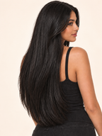 Frau mit langen schwarzen Haaren durch Remy Clip-In Echthaar Extensions